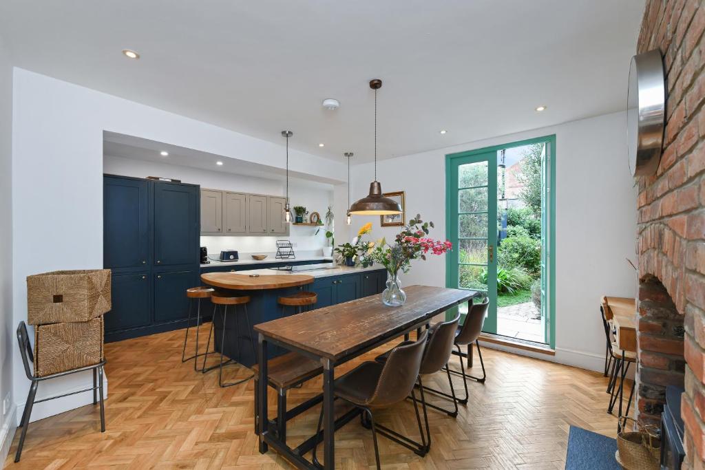 une cuisine avec des placards bleus et une table avec des chaises dans l'établissement Convenient 3-Bed Near Bingham Station & Town Centre, à Bingham