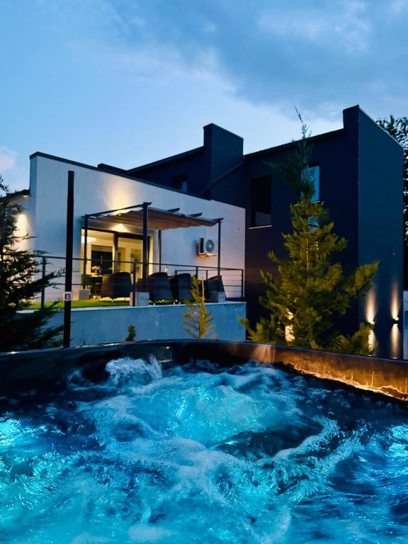 a swimming pool in front of a house at Casa Alma in Piatra Neamţ