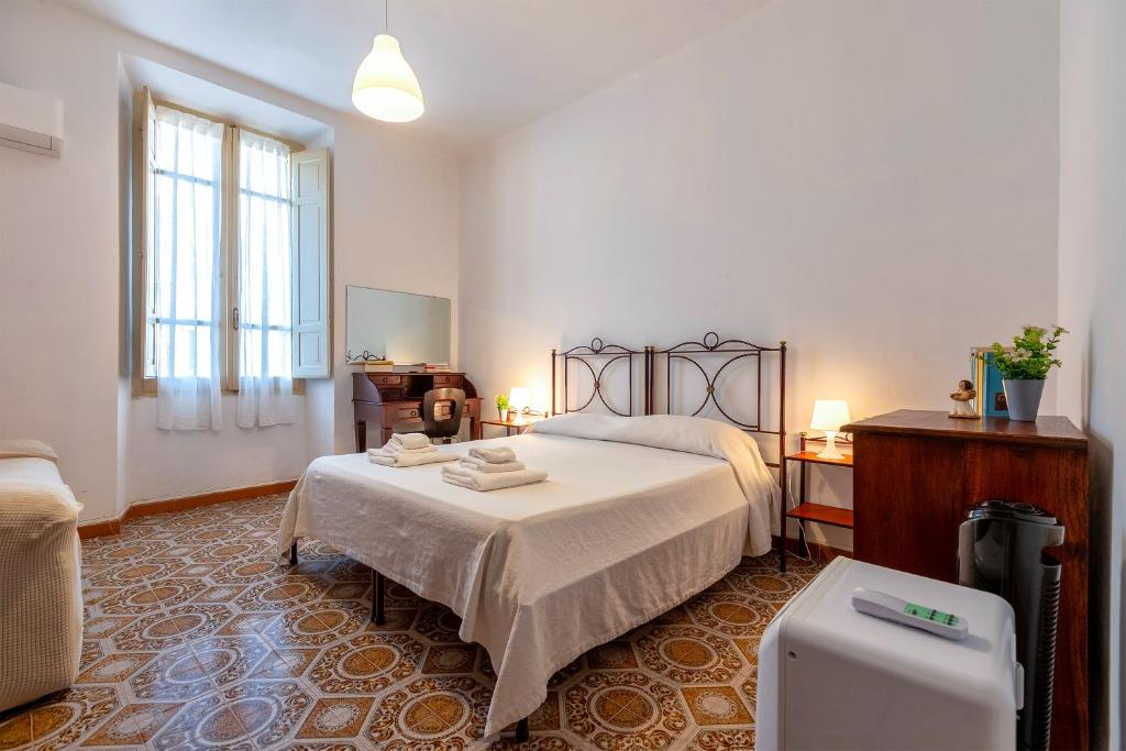 een witte slaapkamer met een bed en een piano bij Mary's House- Alghero in Alghero