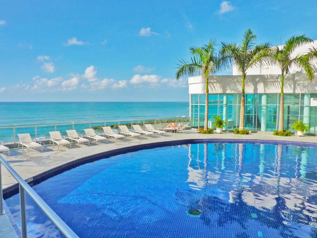 ein Swimmingpool mit Blick auf das Meer in der Unterkunft Apartamentos Palmetto - Frente al Mar in Cartagena de Indias