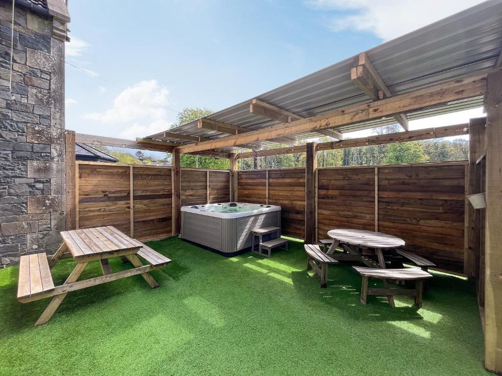 DunragitHome Farm的一个带热水浴缸和野餐桌的庭院