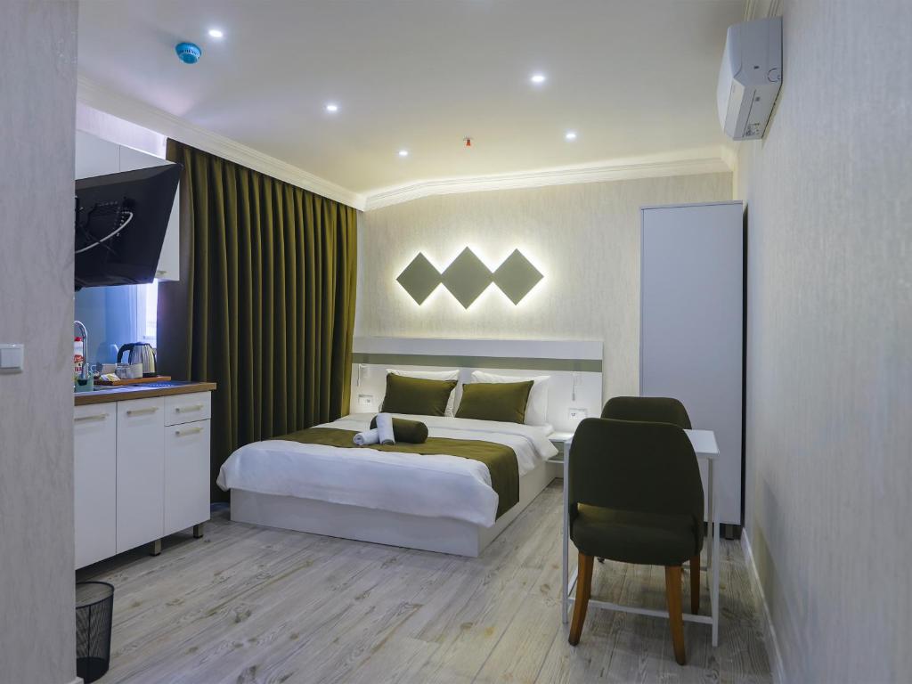 a bedroom with a bed and a table and a chair at Deluna Ümitköy Suite in Çayyolu