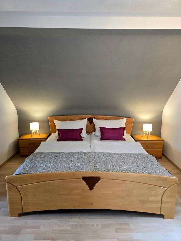 a bedroom with a large bed with two red pillows at Ferienhäuschen in Dickesbach in Dickesbach