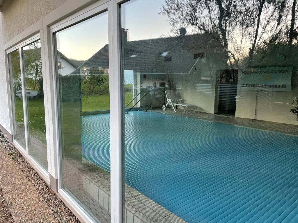 a swimming pool seen through the window of a house at Neue Orchideen-apartments Im Haus in Bad Bergzabern