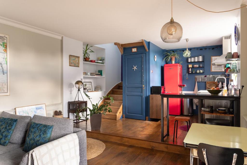 a living room with a blue door and a table at Cottage Thabor - Centre de Rennes in Rennes