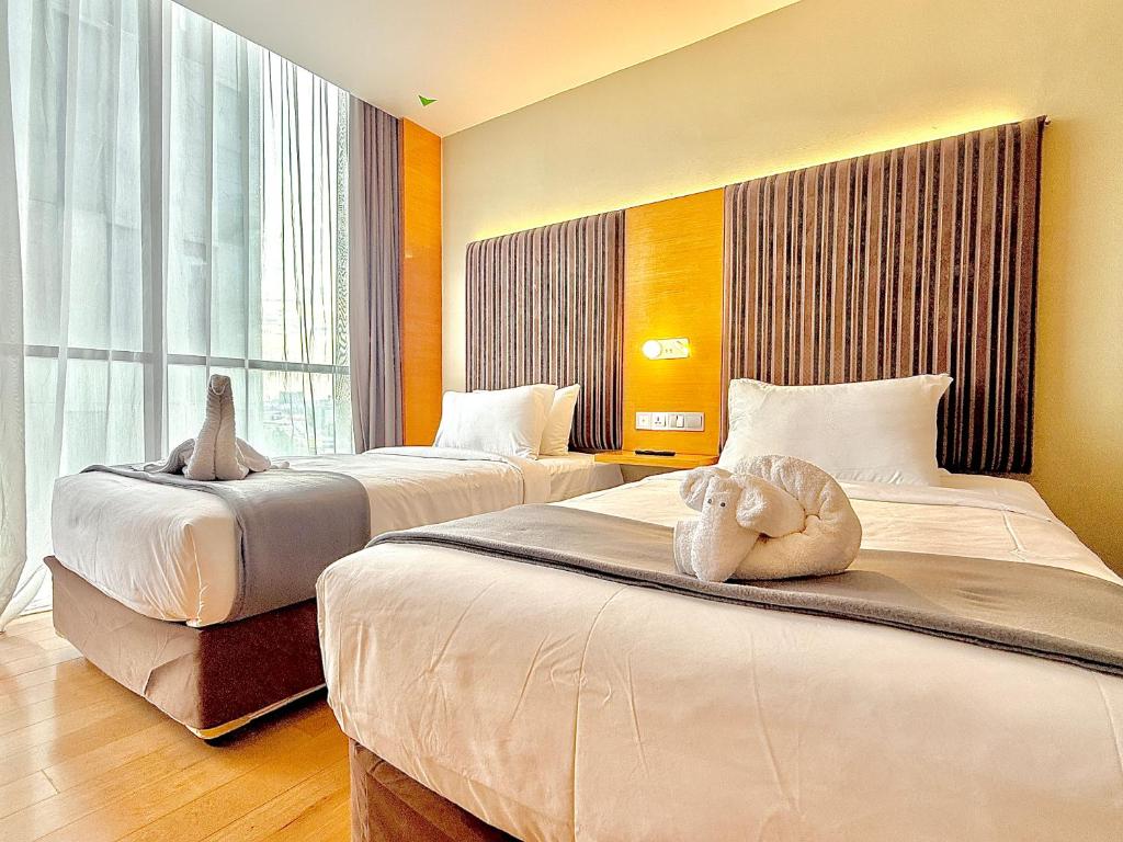 a bedroom with two beds with stuffed animals on them at NuEmpire Subang Suite - Empire Hotel in Subang Jaya