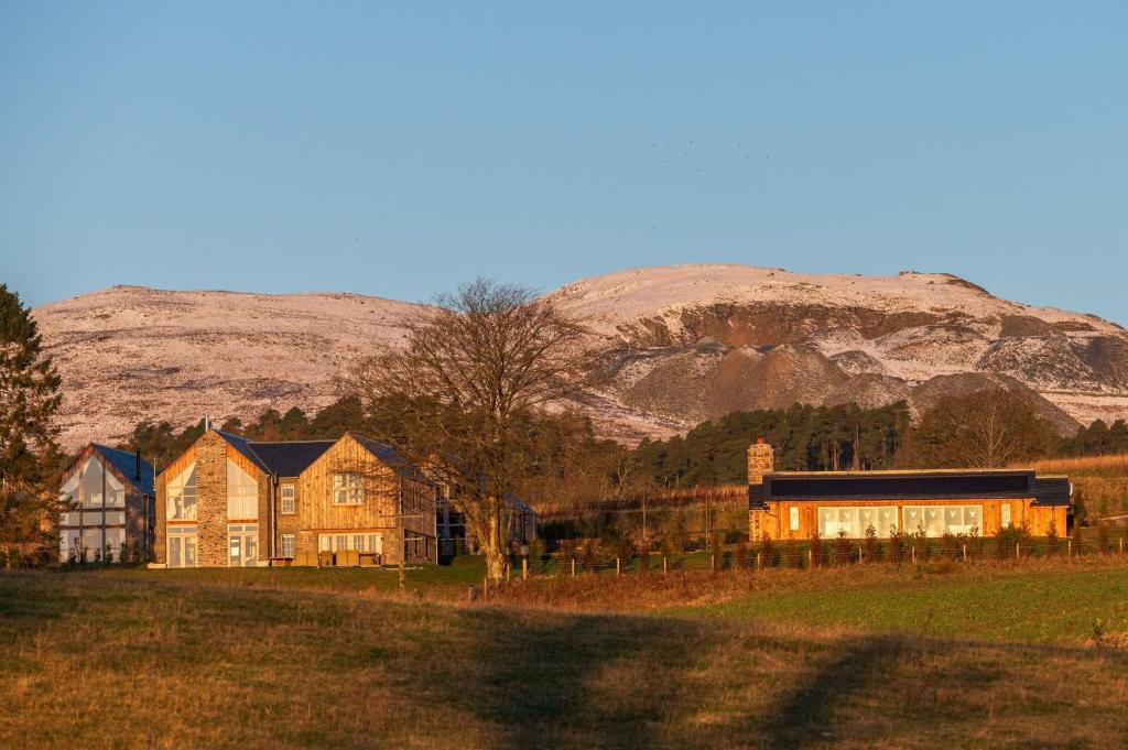 een huis in een veld met een berg op de achtergrond bij Rachel’s Farm, Glenalmond in Inchture