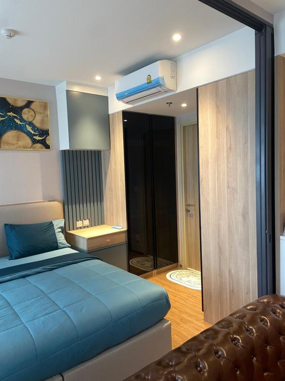 a bedroom with a blue bed and a mirror at Once Pattaya Top Luxury Condo in the City Center in Pattaya Central