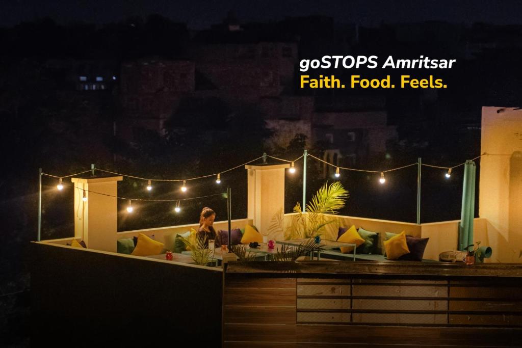 a woman sitting on the roof of a house at night at goSTOPS Amritsar, Chatiwind Gate in Amritsar