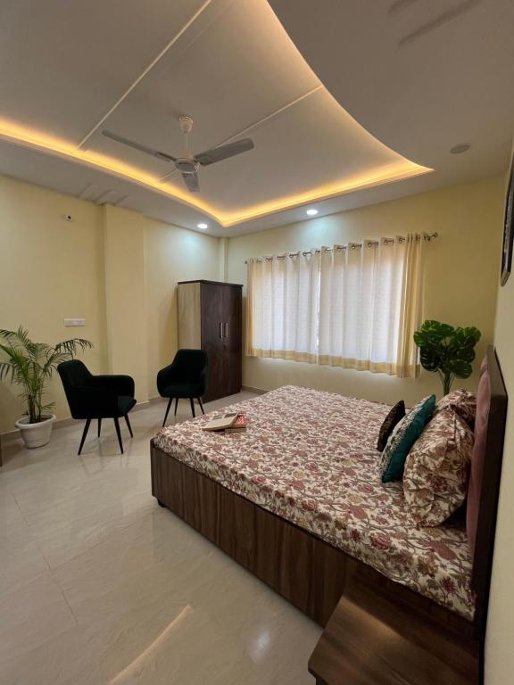 a bedroom with a bed and chairs in a room at TT Homes Homestay for Cozy Family Stay in Jaipur in Jaipur