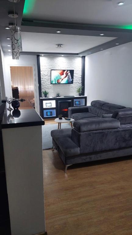 un soggiorno con divani e TV a schermo piatto di Apartment Marković a Bijeljina