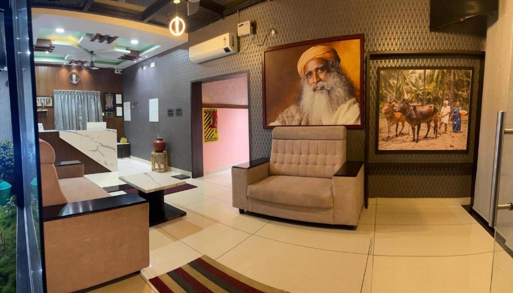 a lobby with a chair and a picture of a guru at Siruvani Residency - Near Isha Foundation Coimbatore in Alāndurai
