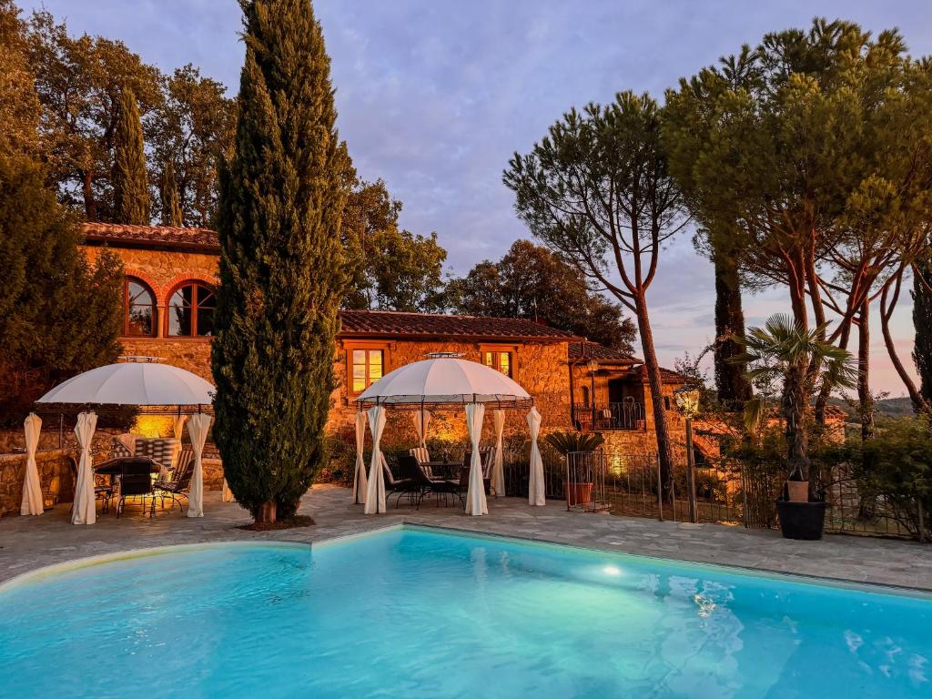 a villa with a swimming pool in front of a house at Poolhouse Oasi del Lupo in Subbiano
