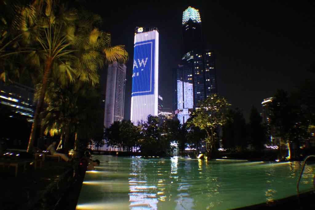 a city skyline at night with a pool of water at KLCC Pavilion Bukit Bintang Agile Hornbill Suites TRX in Kuala Lumpur