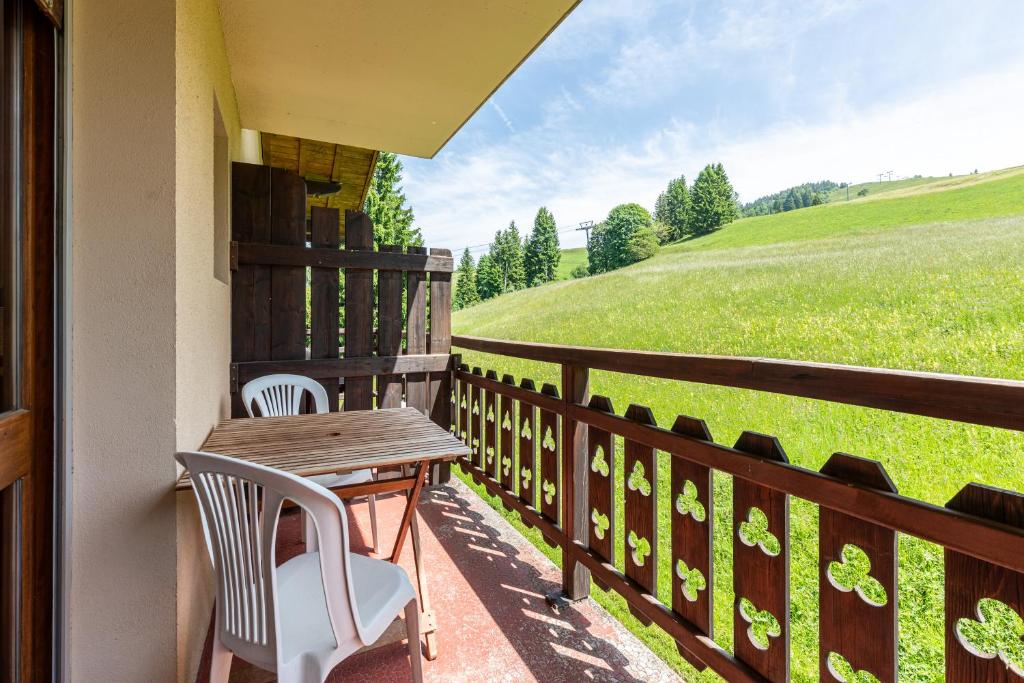 a porch with a wooden table and chairs and a field at Studio 9 - La Palettaz in Crest-Voland