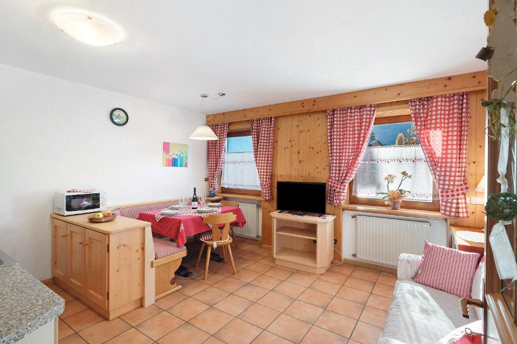 a living room with a table and a television at Ciasa Lino Rotic in Pozza di Fassa