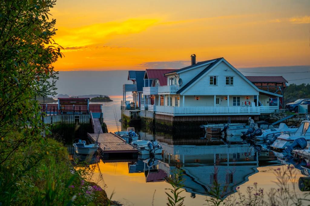 een huis en boten in een jachthaven bij zonsondergang bij Eldur Seaside Cabin in Stavang
