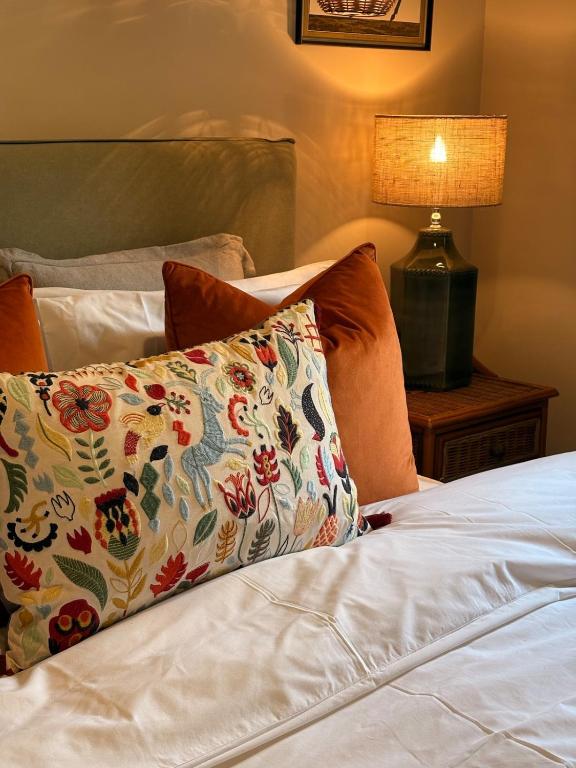 a bed with a pillow on it with a lamp at Holly Cottage - Village location, Lake District in Penrith