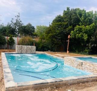 two swimming pools with blue water in a yard at Y & N BnB in Alberton