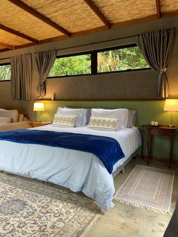 サン・ホッキにあるCanto da Mata - Suíte Exclusiva Sem Vizinhosのベッドルーム1室(大型ベッド1台、青いシーツ、枕付)