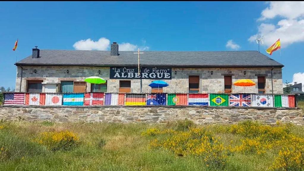 ein Gebäude mit aufgemalten Regenschirmen an der Seite in der Unterkunft Albergue de peregrino Cruz de Fierro in Foncebadón