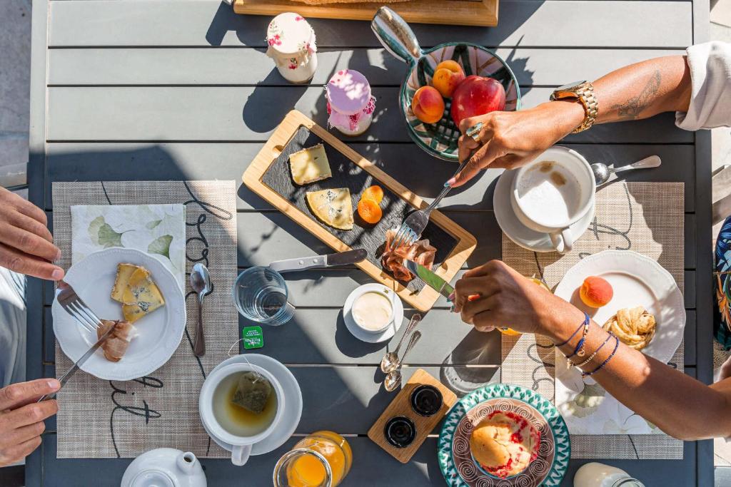 un gruppo di persone sedute attorno a un tavolo che mangiano cibo di La Clé des Chaumes - Chambre d'hôte, Bed and Breakfast avec piscine et bain nordique a Boisset-lès-Montrond