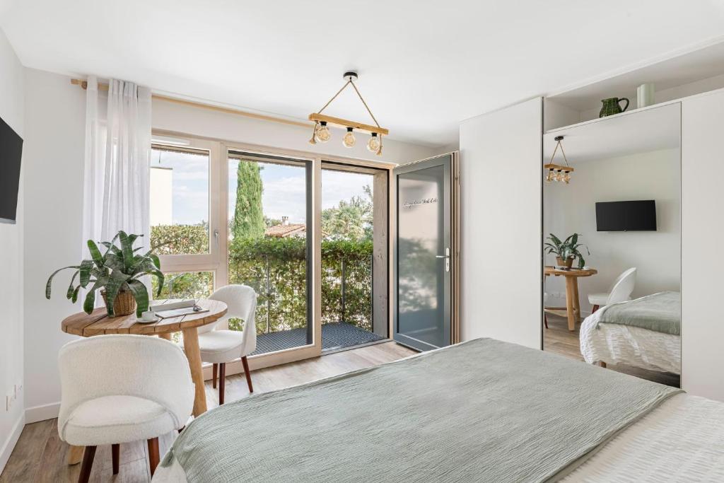 a bedroom with a bed and a table and chairs at La Clé des Chaumes - Chambre d'hôte, Bed and Breakfast avec piscine et bain nordique in Boisset-lès-Montrond