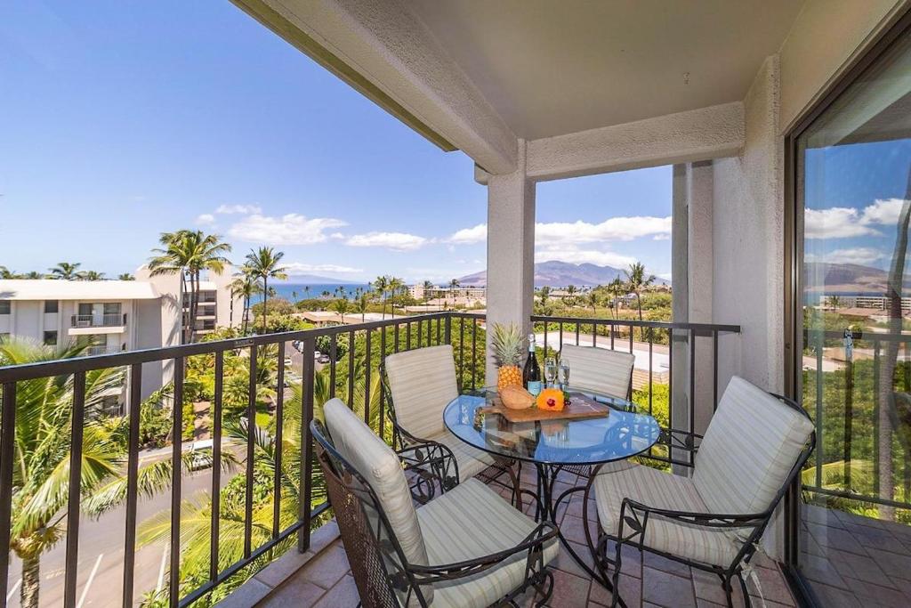 a balcony with a table and chairs and a view of the ocean at Kihei Akahi D402 · AKH D402 2BD Condo Across Beach Ocean View AC in Wailea
