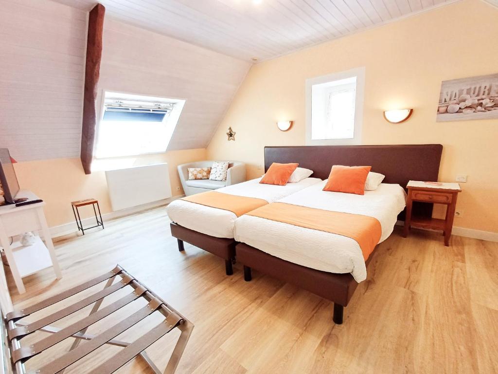 a bedroom with a bed and a bench in it at Chambres D'hôtes De Kerantum in Mahalon