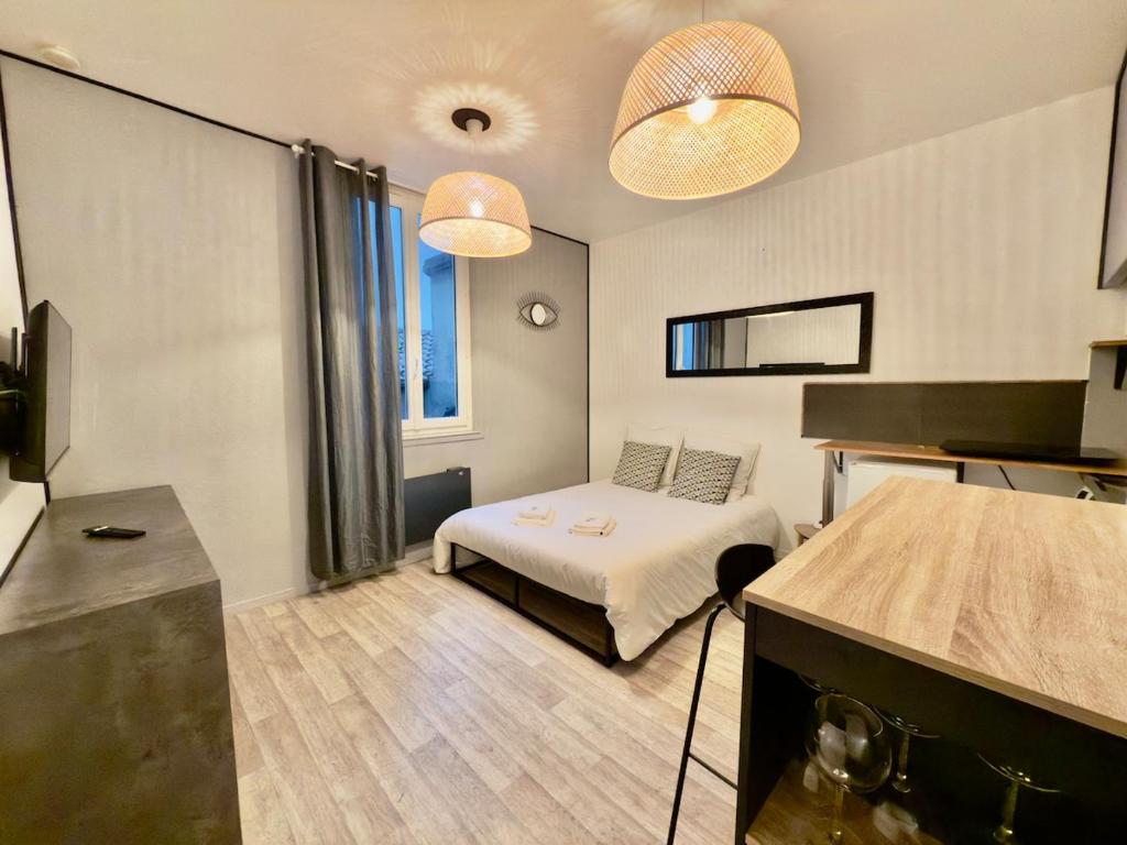 - une chambre avec un lit et deux lumières au plafond dans l'établissement Studio 2 calme Av Georges Dumas - DABNB, à Limoges