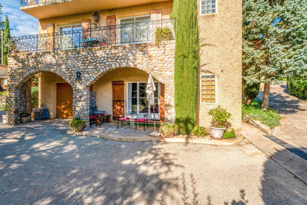 a stone house with a balcony and a yard at Gîte Le Séguret in Entrechaux