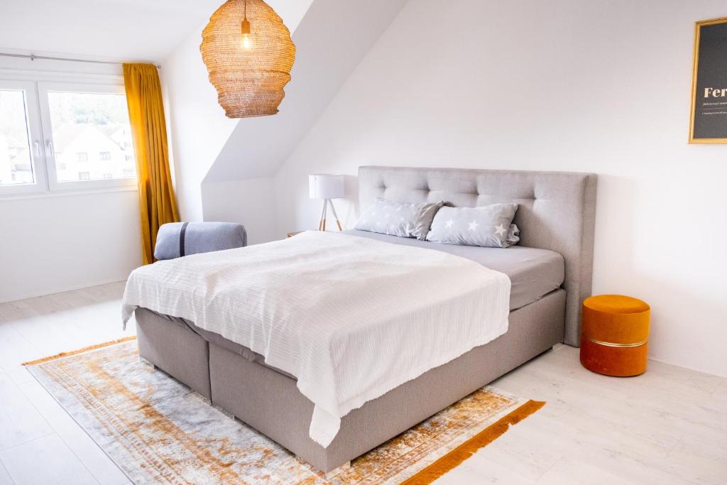 a white bedroom with a large bed with white sheets at Appartement Seeblick in Lindau