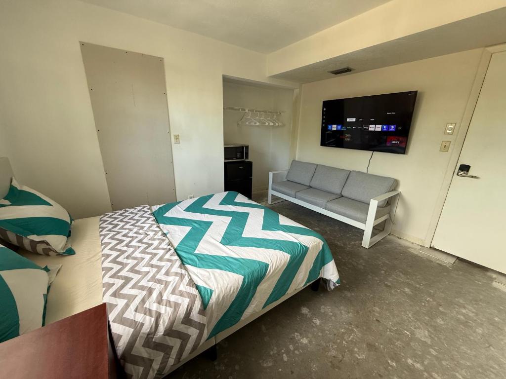 a bedroom with a bed and a couch and a flat screen tv at Happy Vacation in Largo