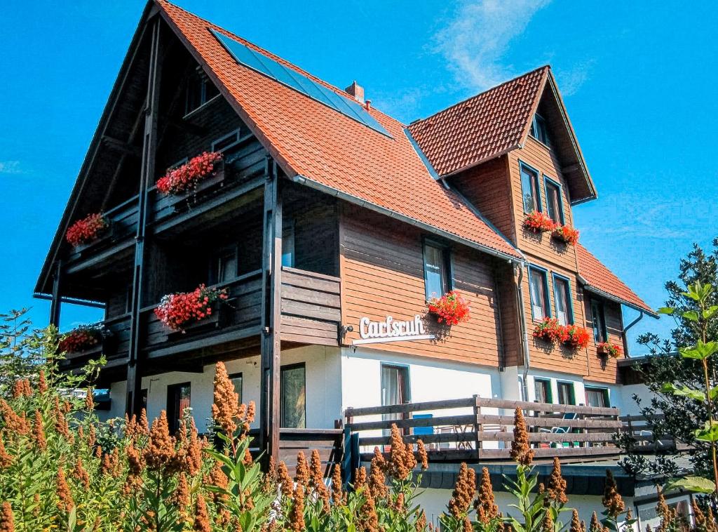 a large house with flowers on the front of it at Hotel Carlsruh in Braunlage