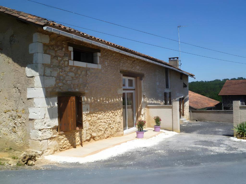 a stone house with a door and a window at Le Séchoir D'Alice in Mauriac