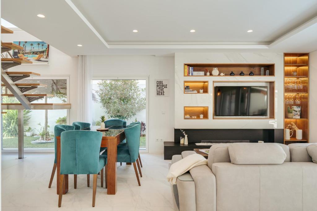 ein Wohnzimmer mit einer Couch und einem Tisch und Stühlen in der Unterkunft Paraty Villa in Aroeira