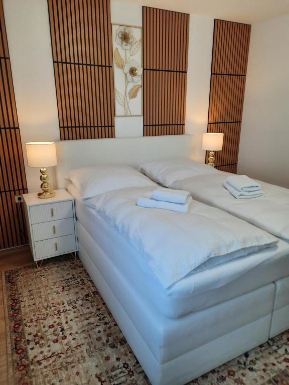 ケーニッヒスブルンにあるModerne 3Zimmer Wohnung, in Königsbrunn bei Augsburgのベッドとタオル2枚のある寝室