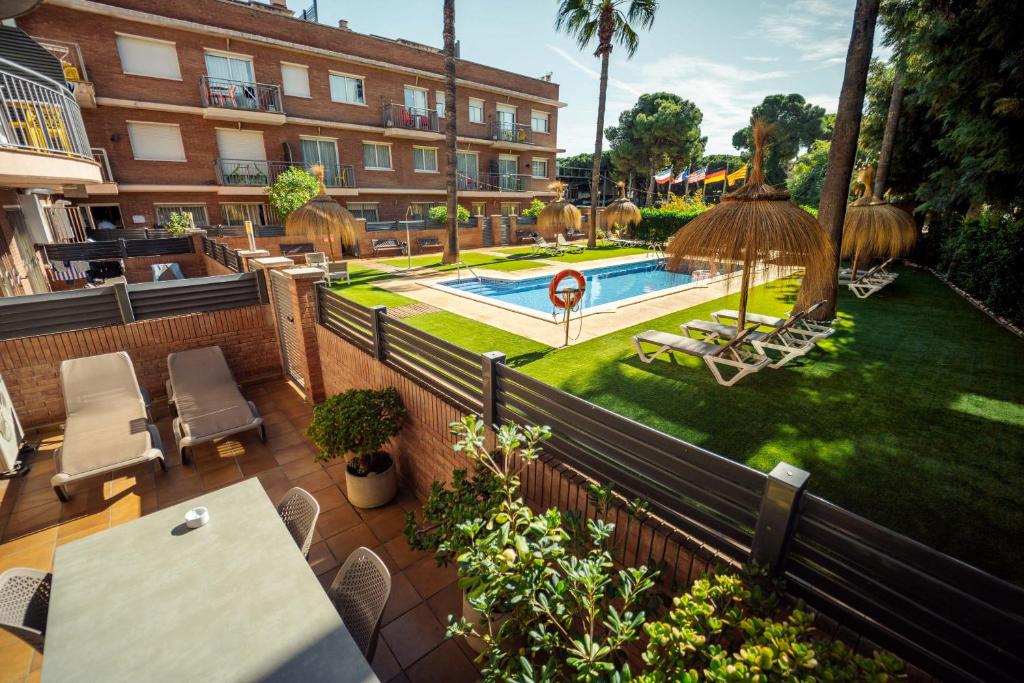 an outdoor patio with a table and a swimming pool at Apartamentos Velor in Castelldefels