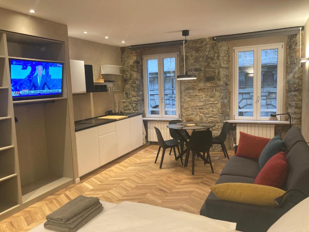 a living room with a couch and a kitchen with a table at Trieste City 1 in Trieste