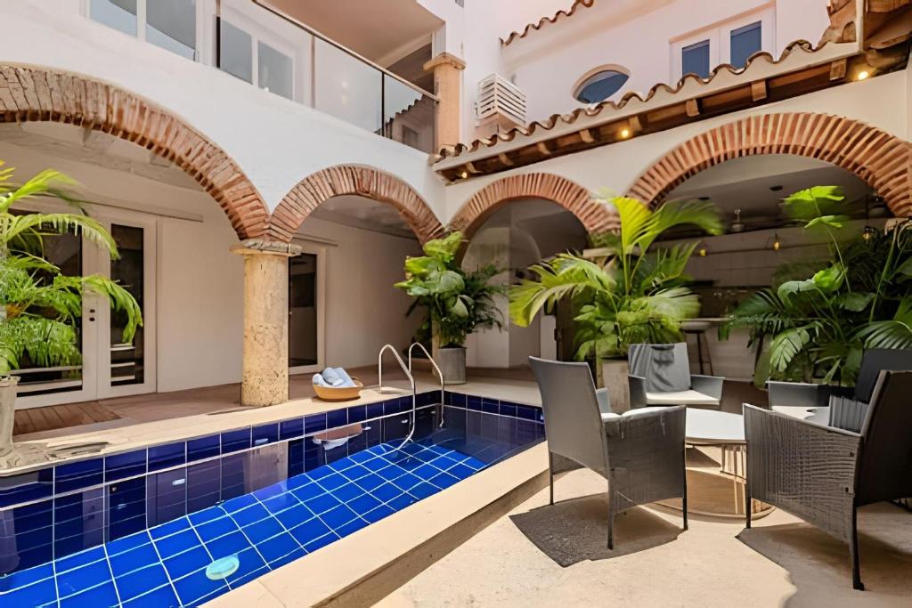 una piscina coperta con sedie e tavolo in un edificio di Casa Bóvedas - Paraíso de 5 habitaciones a Cartagena de Indias
