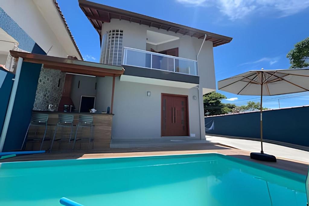 a villa with a swimming pool and a house at Bertioga Sobrado Piscina 90m da Praia da Enseada in Bertioga