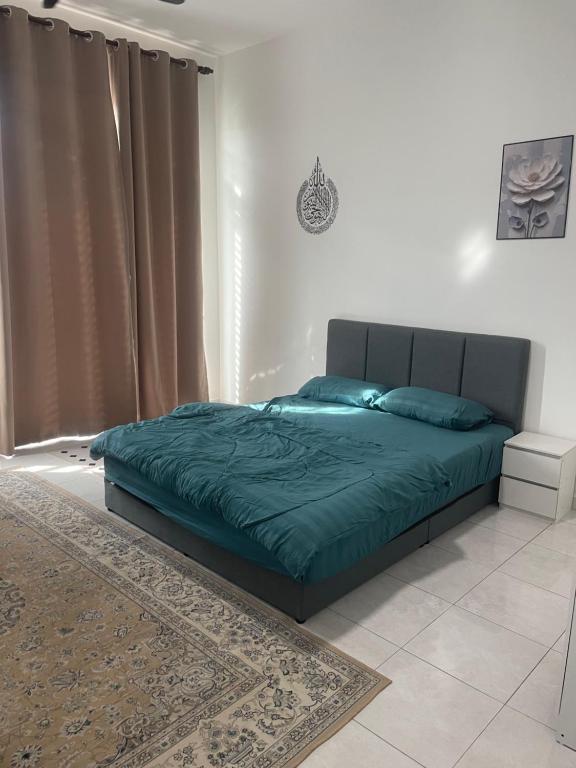 a bedroom with a bed with a green comforter at Anis Homestay MELAKA in Melaka