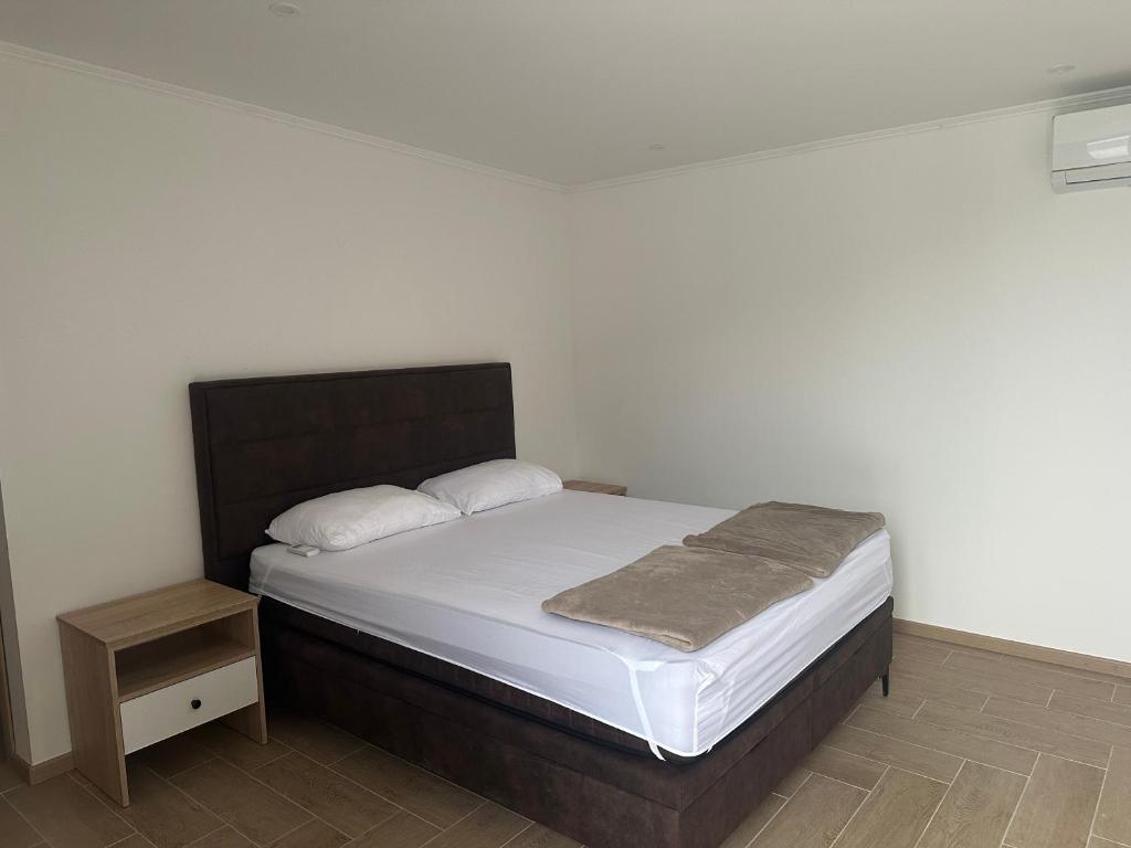 1 cama con sábanas blancas y cabecero marrón en una habitación en Daisy2, en Banja Luka