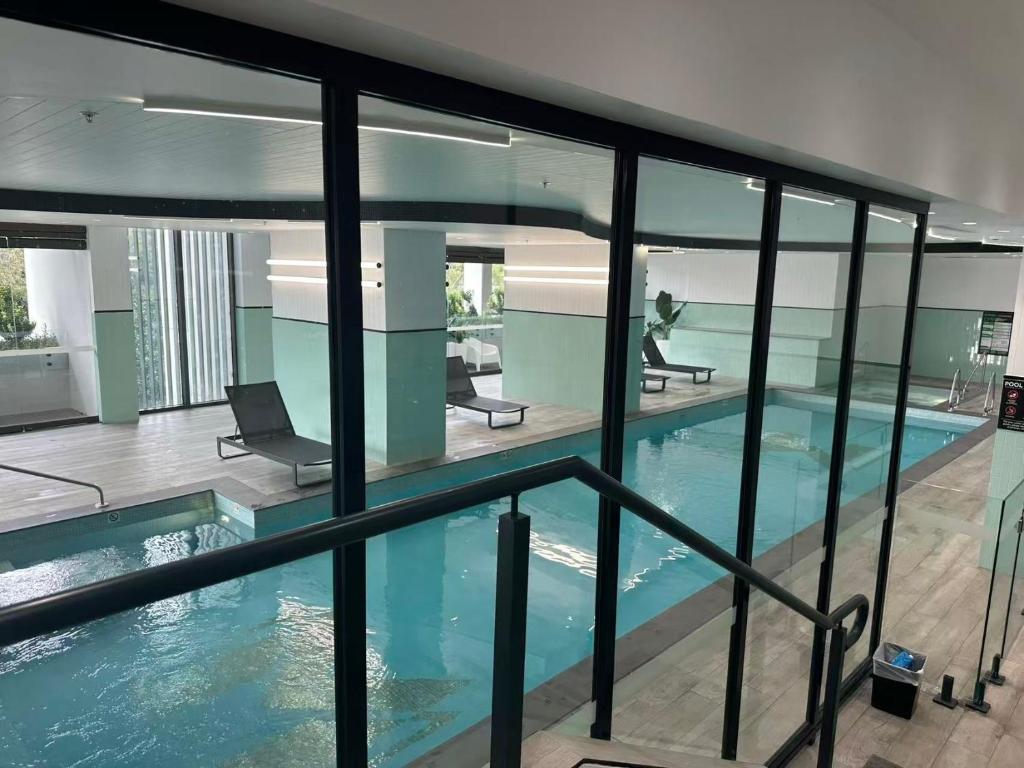 a swimming pool in a building with glass windows at Meriton Parramatta in Sydney