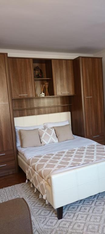 a bedroom with a large white bed with wooden cabinets at Studio O&A in Cristian