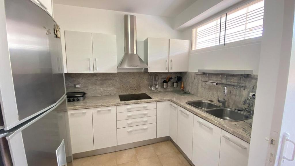 eine Küche mit weißen Schränken und einem Edelstahlkühlschrank in der Unterkunft Apartamento con Vista al mar y Terraza, Isla de Margarita in Pampatar