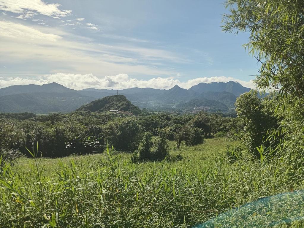 a view of a green field with mountains in the background at la kaza in Le Morne Rouge