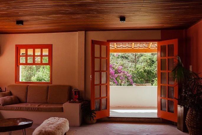 ein Wohnzimmer mit einer Couch und zwei Fenstern in der Unterkunft Casarão in Marechal Floriano