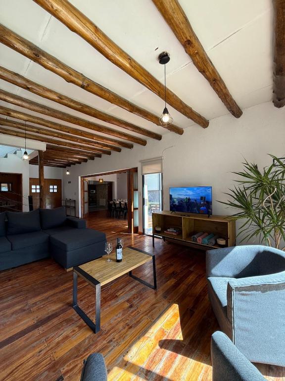 a living room with blue couches and a tv at Gran Casa con Piscina in Ciudad Lujan de Cuyo