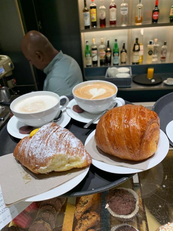 two loaves of bread and two cups of coffee on a table at Brera home suite in Milan